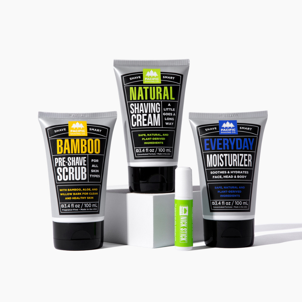 Set of Pacific Shaving Company grooming products including pre-shave scrub, natural shaving cream, everyday moisturizer and Nick Stick on a white background