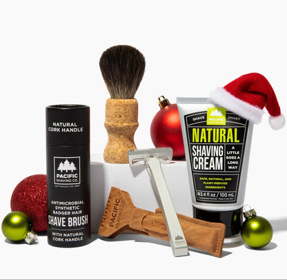 Pacific Shaving Company shaving products including a brush, cream, and razor on a white background with Christmas decorations.