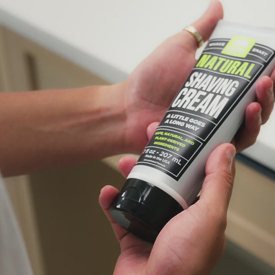 GIF of person looking at shaving cream tube and dispensing product in hand