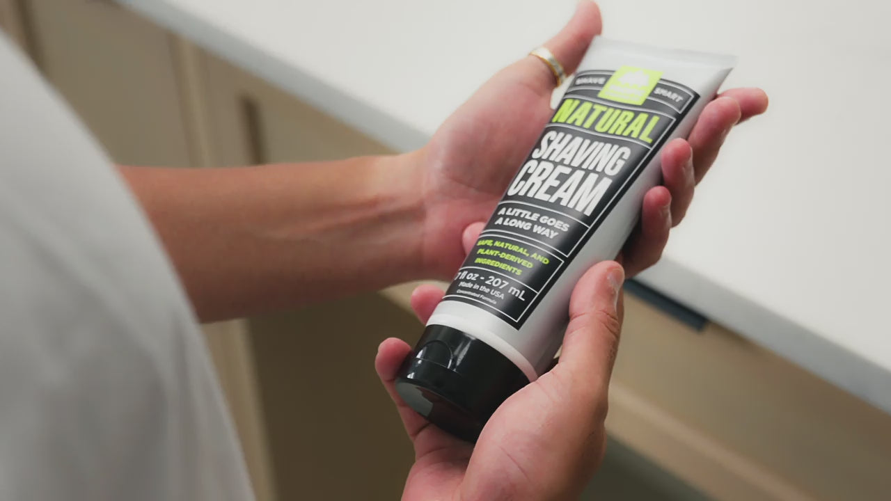 GIF of person looking at shaving cream tube and dispensing product in hand